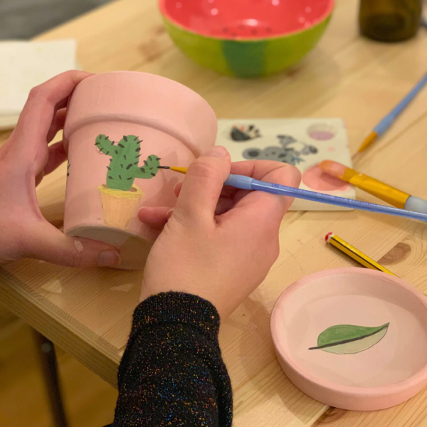 Cours de peinture sur céramique dans un atelier de poterie.